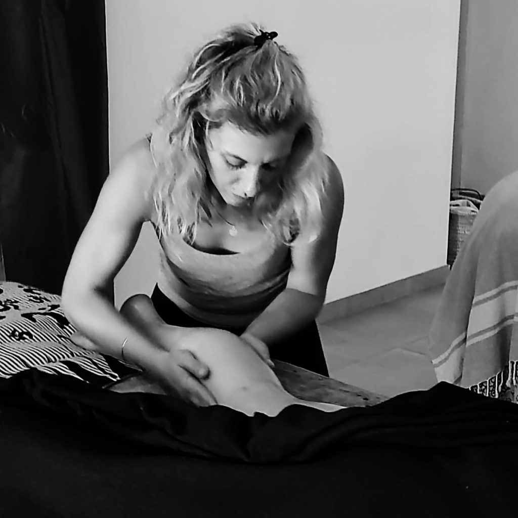 personne massant la jambe d'une autre personne